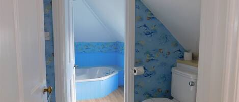 A bathroom with a toilet, a bathtub, and a shower.