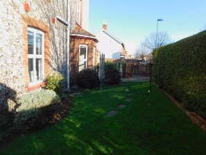 Stunning garden surrounds a charming residence with a blend of traditional and modern architectural styles.
