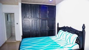 Une chambre à coucher avec un lit, une armoire et une porte donnant sur la salle de bain.