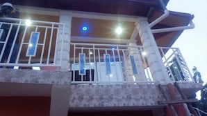 Un bâtiment doté d’un balcon, d’une façade carrelée et d’une porte bien visible.