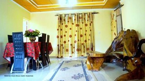 A room with a wooden ceiling, a dining table with chairs, a decorative wooden chair, and a curtain with polka dots. - ❄✨ Ocean front,  rooftop , gated single family beach house withsecurity guard❤️ (Limbe)