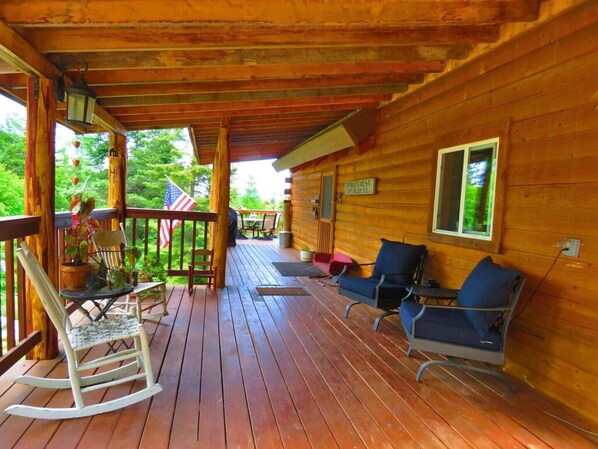 A wooden cabin with a porch, rocking chair, and two blue chairs. - Pinecrest Cabin- a relaxing mountain cabin close to town (Lakeside)