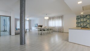 A spacious living area with a dining table, a fireplace, and a kitchen counter. - Villa M&J La Puebla de Cazalla by Ruralidays (Sevilla)