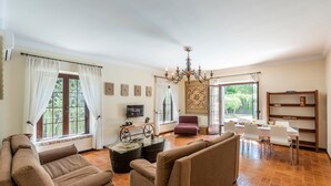 Ein geräumiges Wohnzimmer mit einer Sofagarnitur, einem Couchtisch und einem Essbereich mit Stühlen und Tisch.