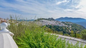 A coastal town with white buildings, a prominent hilltop structure, and lush greenery. - Casa de la Abuela Gaucín by Ruralidays (Málaga)
