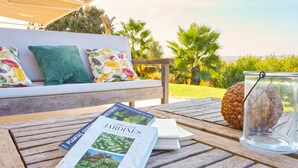 Ein Holztisch mit einem Buch mit dem Titel 'Como Llen Jardines' und einem Glasgefäß mit einer Kiefernzapfen.
