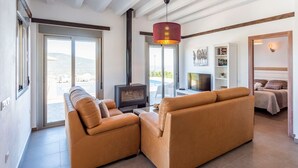 Un salon moderne avec un canapé, un téléviseur et une cheminée.