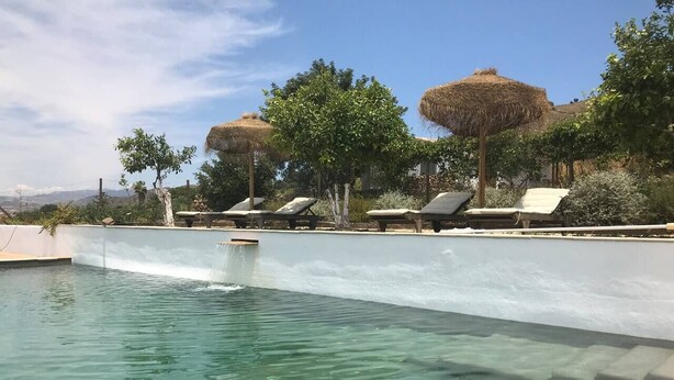 A clear pool with lounge chairs and thatched umbrellas. - 3-Bed Andalusian House with Private Pool & Garden! (Pizarra)