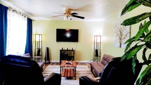 A living room with a ceiling fan, a flat-screen TV mounted on the wall, a coffee table, and two sofas. - (M1) Enchanted Getaway ☀ 3-Mins Walk To River❣ (Carlsbad)