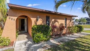 Stucco exterior and well-manicured grounds surround this single-story residence.