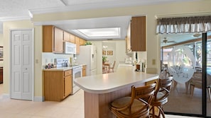 Enjoy meals in the kitchen with a central island, dining area, and large window offering a view of the outdoor space.