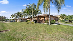 Situated in a suburban neighborhood, this single-story house offers an entrance and a lush, tropical setting.