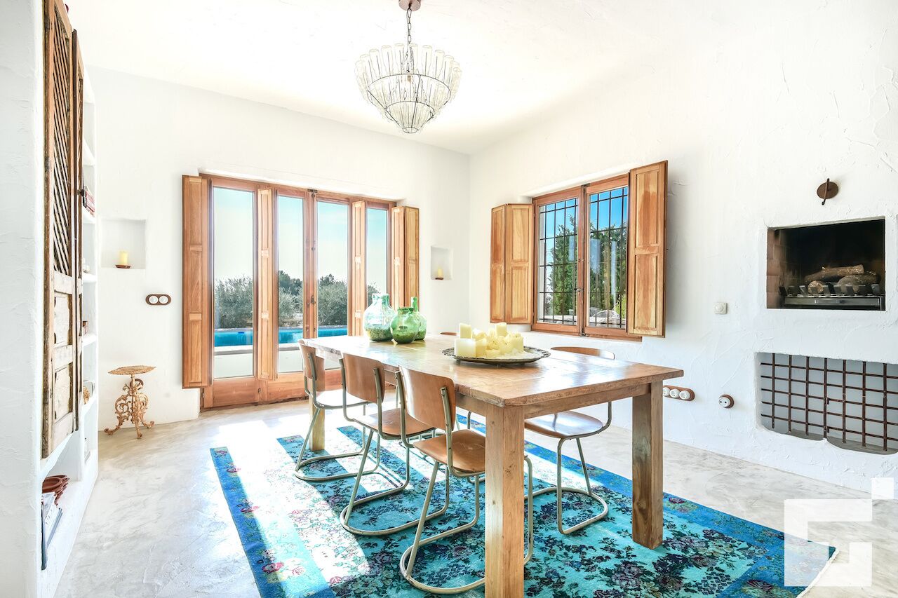 A dining area with a wooden table, chairs, and a chandelier.