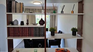 A bookshelf with books, decorative items, and a small car model. - Beautiful 3 Bedroom Home in Staines Private Parking, Garden, Near Heathrow (Staines-upon-Thames)