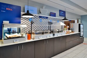Montaje de bufé con estaciones de comida señalizadas, una estación de café y un dispensador de yogur.