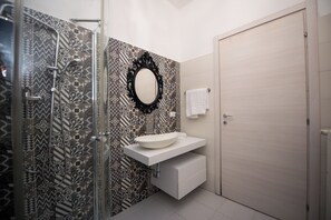 Economy appartement | Badkamer | Een douche, handdoeken, zeep, shampoo