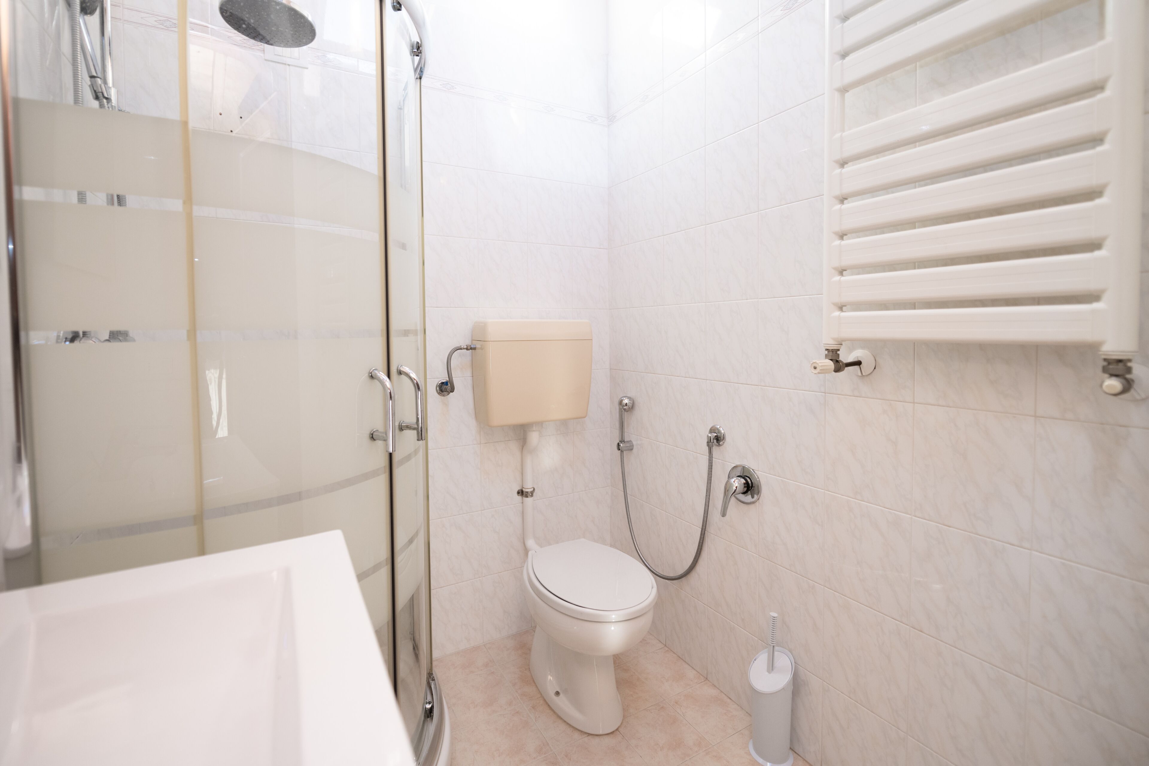 Ein modernes Badezimmer mit Duschkabine aus Glas, Toilette und Badewanne.