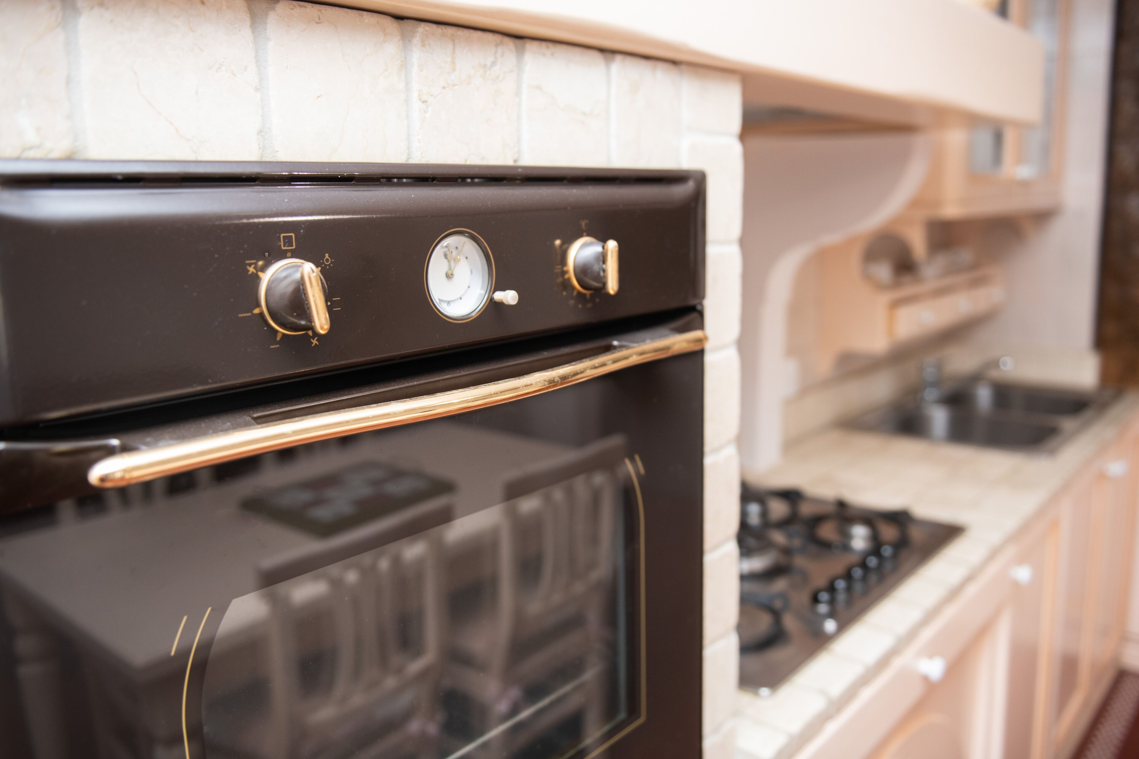 A kitchen with a black oven, a gas stove, and a white tiled backsplash.