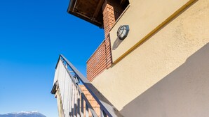 Un bâtiment doté d’un balcon en bois, avec une montagne en arrière-plan.
