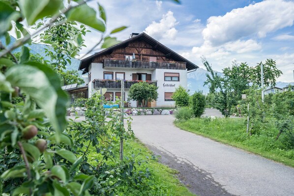 Un bâtiment à deux étages doté de balcons, une enseigne indiquant « Leichtlhof », et un chemin menant à l’entrée.