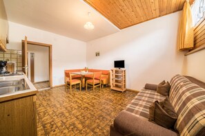 Un espacio habitable pequeño con kitchenette, comedor y sofá.