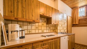 Una cucina con mobili in legno, una macchina da caffè, un tostapane e un frigorifero.