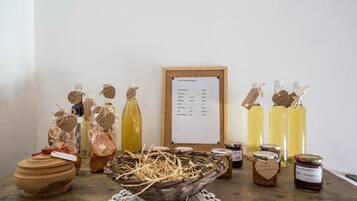 Esposizione di diversi prodotti alimentari, tra cui vasetti e bottiglie, con etichette e un menu su una bacheca.