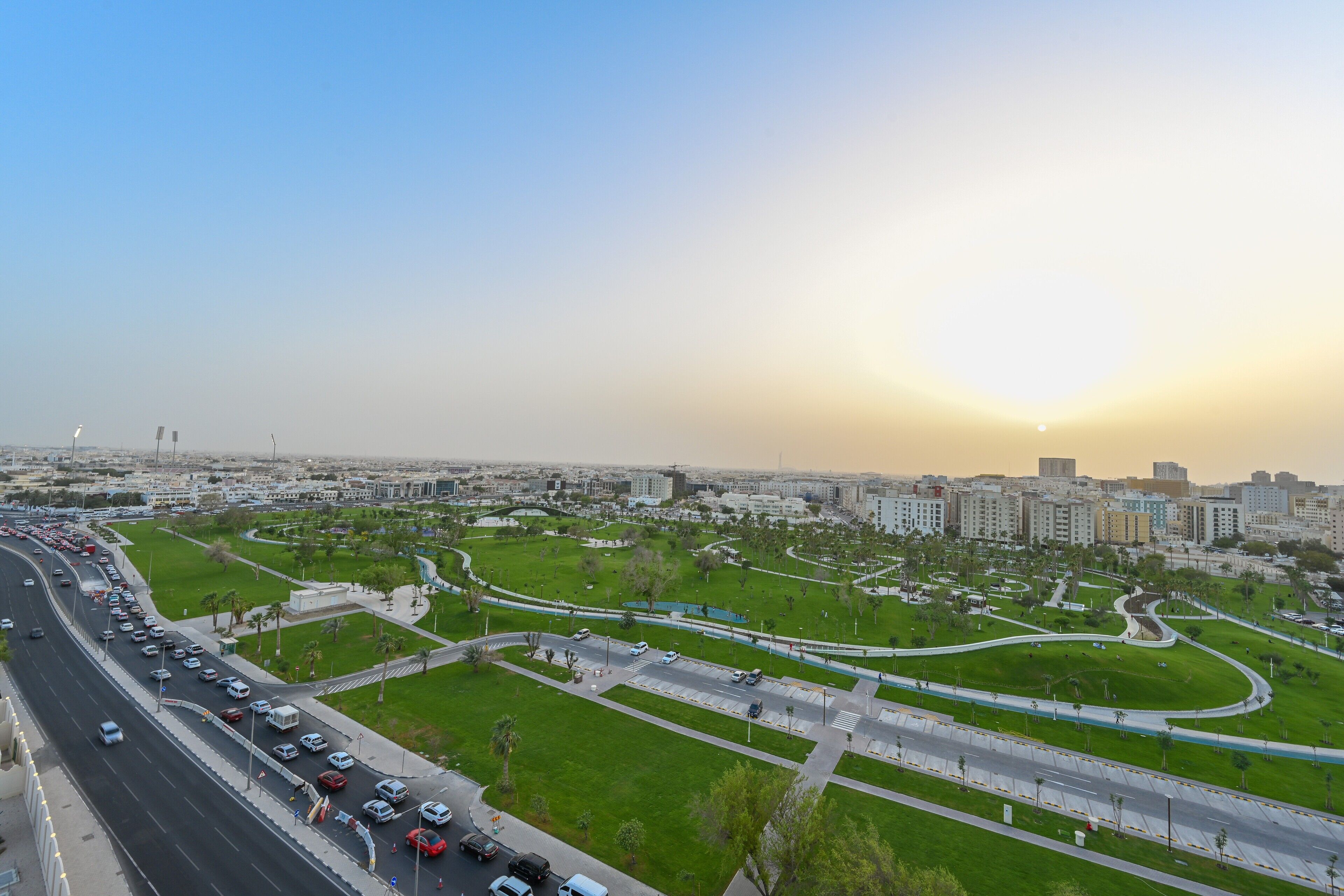 Un paisaje urbano con autopista, áreas verdes y edificios.