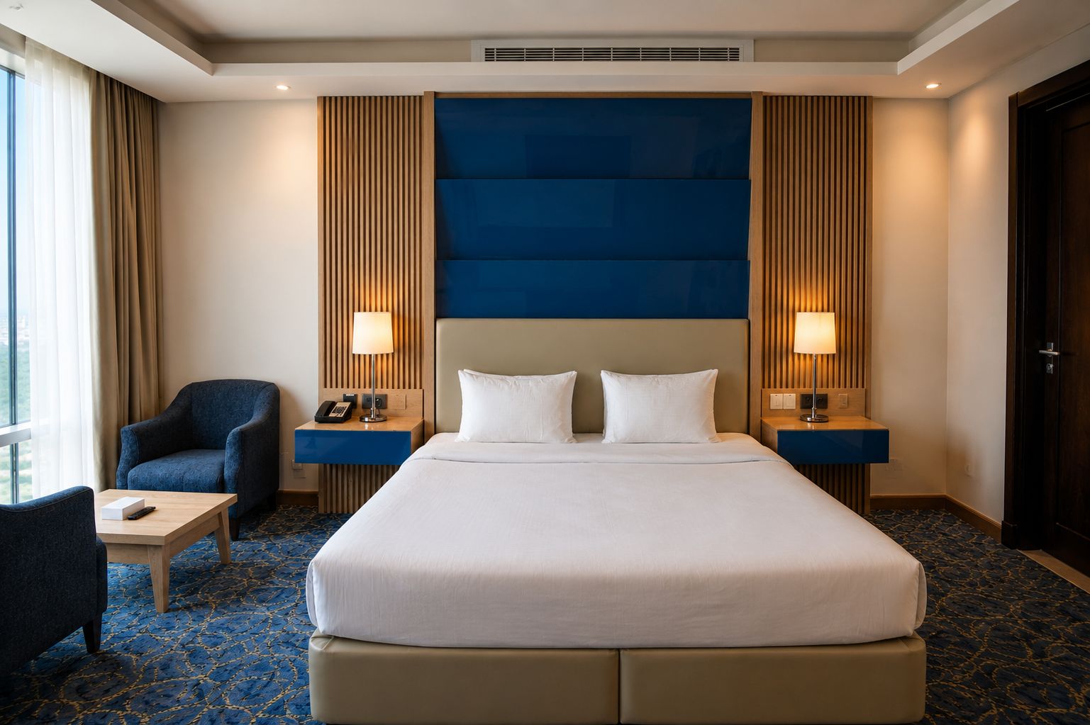 A hotel room with a large bed, two bedside tables, a chair, and a desk.