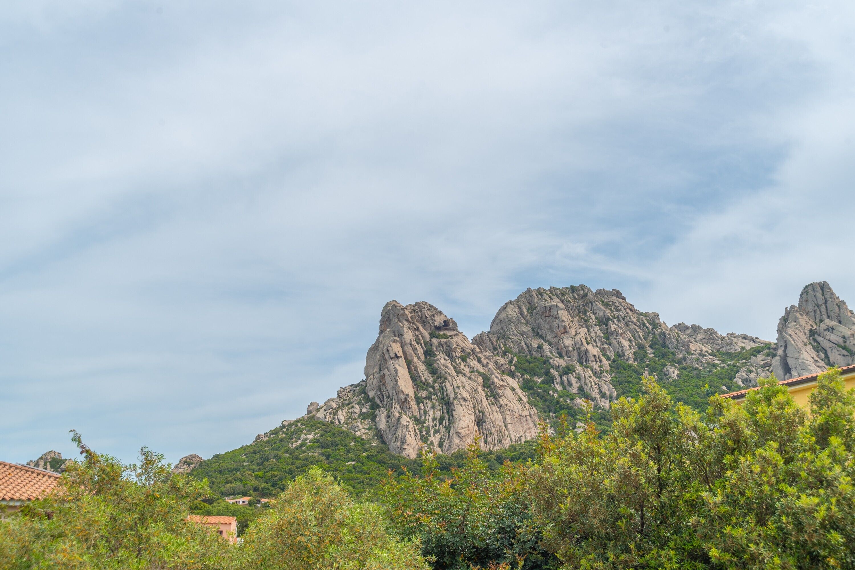 A mountainous landscape with rocky cliffs and greenery.