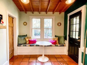A cozy room with a bench, a round table, and two windows. - Steps to Dining, Shopping, 3 Minute Walk to Beach (Folly Beach)