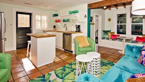 A compact living space with a kitchenette, a green chair, a blue sofa, and a small round table. - Steps to Dining, Shopping, 3 Minute Walk to Beach (Folly Beach)