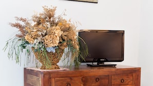 Ein Holzschrank mit einem Fernseher und einer dekorativen Blumenkomposition.