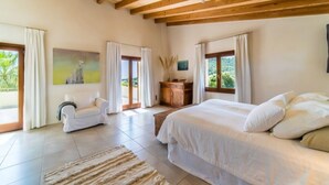 A bedroom with a large bed, a sofa, a wooden cabinet, and a painting on the wall. - Villa "Son Sard" with Sea & Mountain View, Pool, A/C, Balcony, Garden & Terrace (Son Servera)