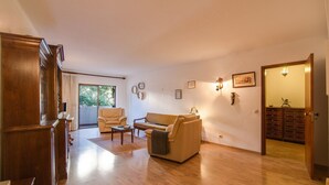 Un salón amplio con sofá, mesa de centro y aparador de madera.