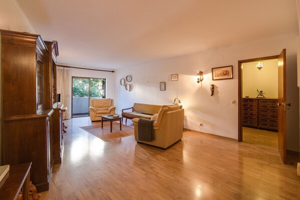 A spacious living room with a sofa, a coffee table, and a wooden cabinet.
