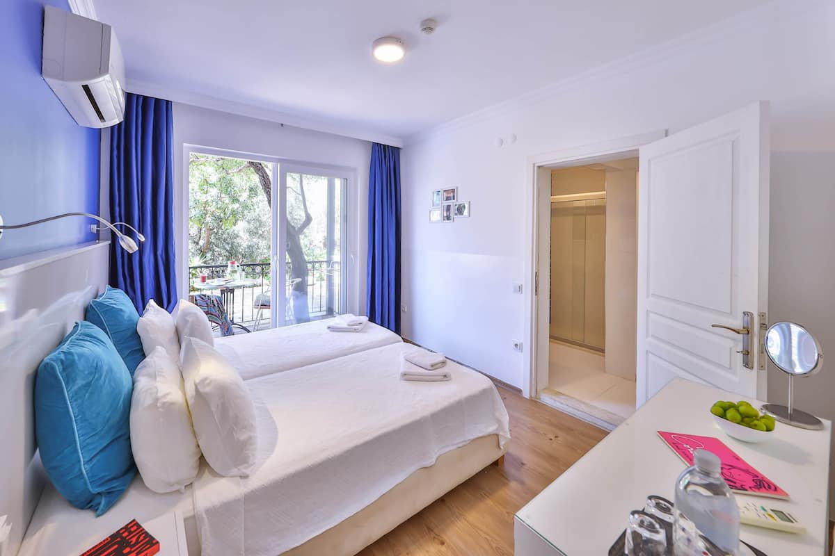 Ein Hotelzimmer mit Bett, Schreibtisch mit Spiegel und Badezimmertür.