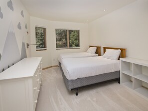 Un dormitorio con dos camas, un escritorio y una cómoda.