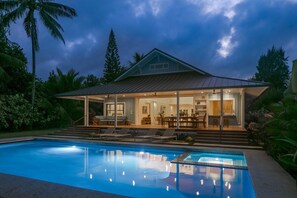 Uma casa moderna com piscina, janelas amplas e área de varanda coberta.