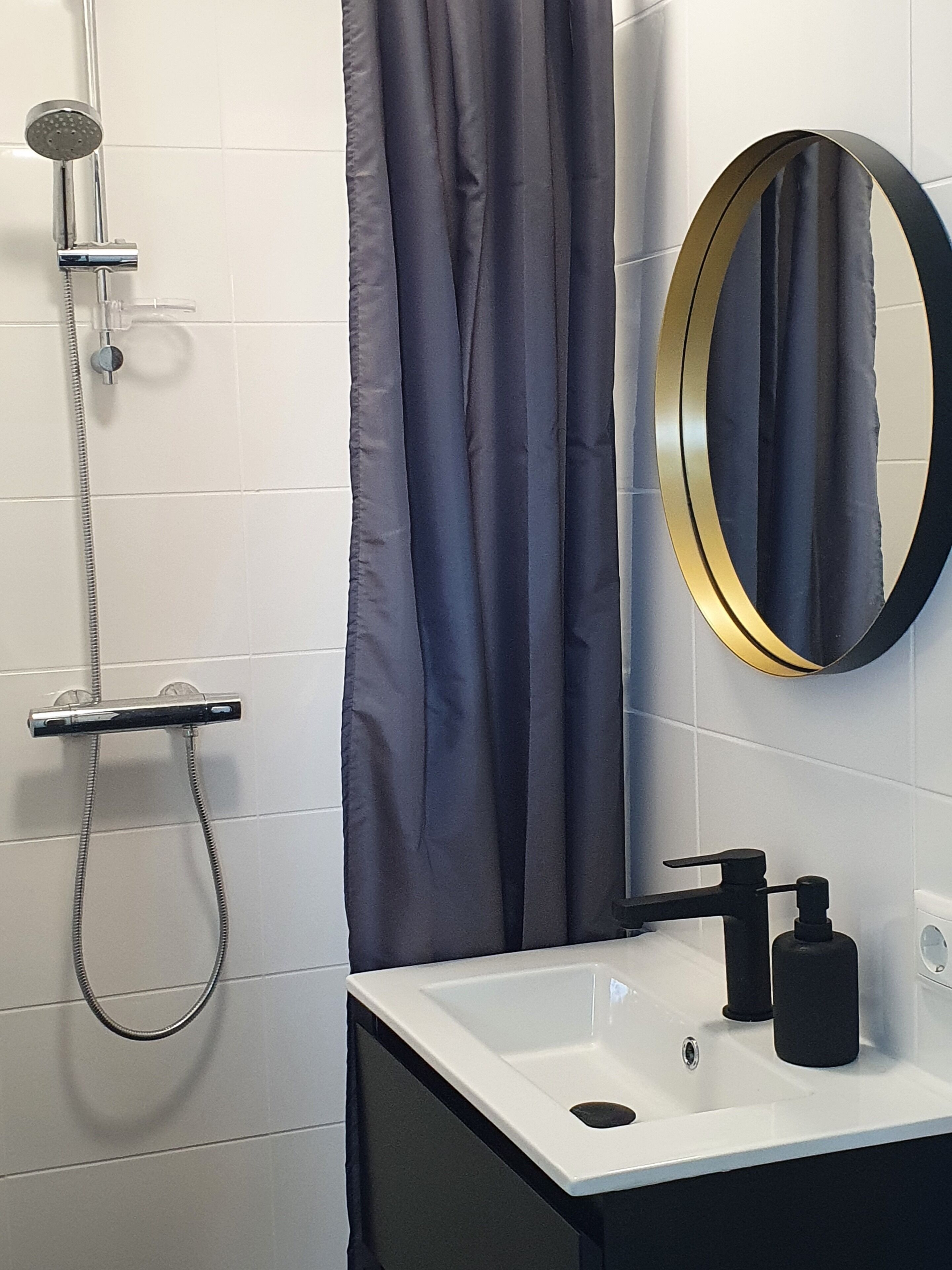 Un baño moderno con ducha, lavabo y espejo.
