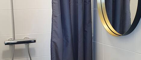 Un baño moderno con ducha, lavabo y espejo.