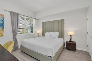 A bedroom with a bed, bedside tables, a chair, and a window with curtains.