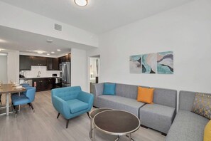 A modern living area with a sofa, armchairs, and a dining table. - Resort Condo 3BR w Balcony, Free Parking near OCCC (Orlando)