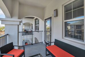 A balcony with a view of a residential area, a railing, and a door leading to an interior space. - Resort Condo 3BR w Balcony, Free Parking near OCCC (Orlando)