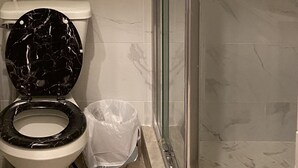 Kylpyhuone, jossa on wc, suihku ja pyyheteline.
