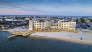 A coastal building with a waterfront promenade, a pier, and a parking area.