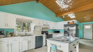 A modern kitchen with white cabinets, stainless steel appliances, and a central island. - Enchanting, Romantic Lakefront Cottage, Close to Frankenmuth (Millington)