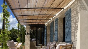 An outdoor seating area with wooden furniture and a pergola.