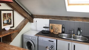 A compact kitchen with a washing machine, a dishwasher, a wooden countertop, a sink, and a window. - Biarritz T3 Quiet + Parking + Côte des basques + Halles (Biarritz)