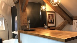 A kitchen with wooden beams, a white countertop, and two pendant lights. - Biarritz T3 Quiet + Parking + Côte des basques + Halles (Biarritz)